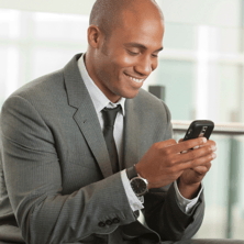 business man texting, smiling at his phone