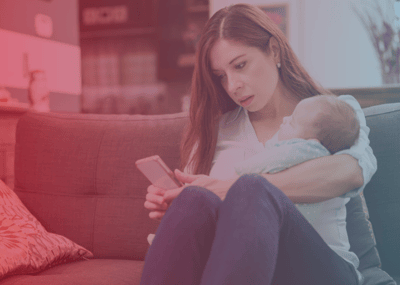 mom holding small baby texting on phone