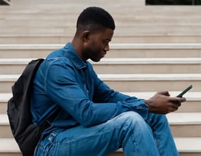 College-student-sitting-on-the-stairs-texting