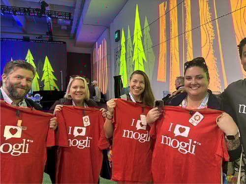 Mogli clients holding up “I love Mogli” t-shirts at Dreamforce