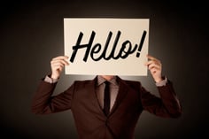 Young businessman hiding behind a greeting drawn on paper-1