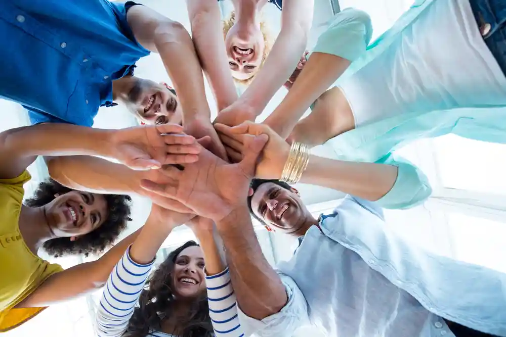 Creative team putting their hands together in circle_11zon