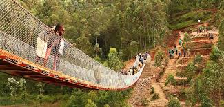 people walking standing on a rural bridge, built by Bridges to Prosperity, a client of Mogli: SMS & WhatsApp for Salesforce